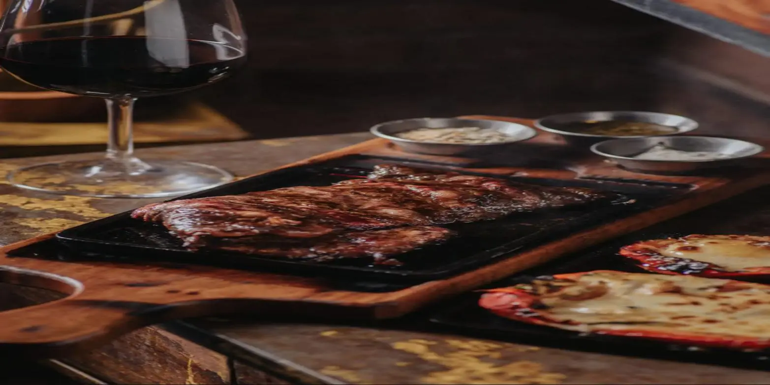 Entraña sobre plancha de hierro con vino