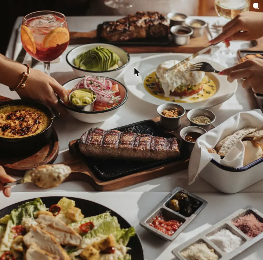 Mesa servida: bife de chorizo, burrata, palta y spritz